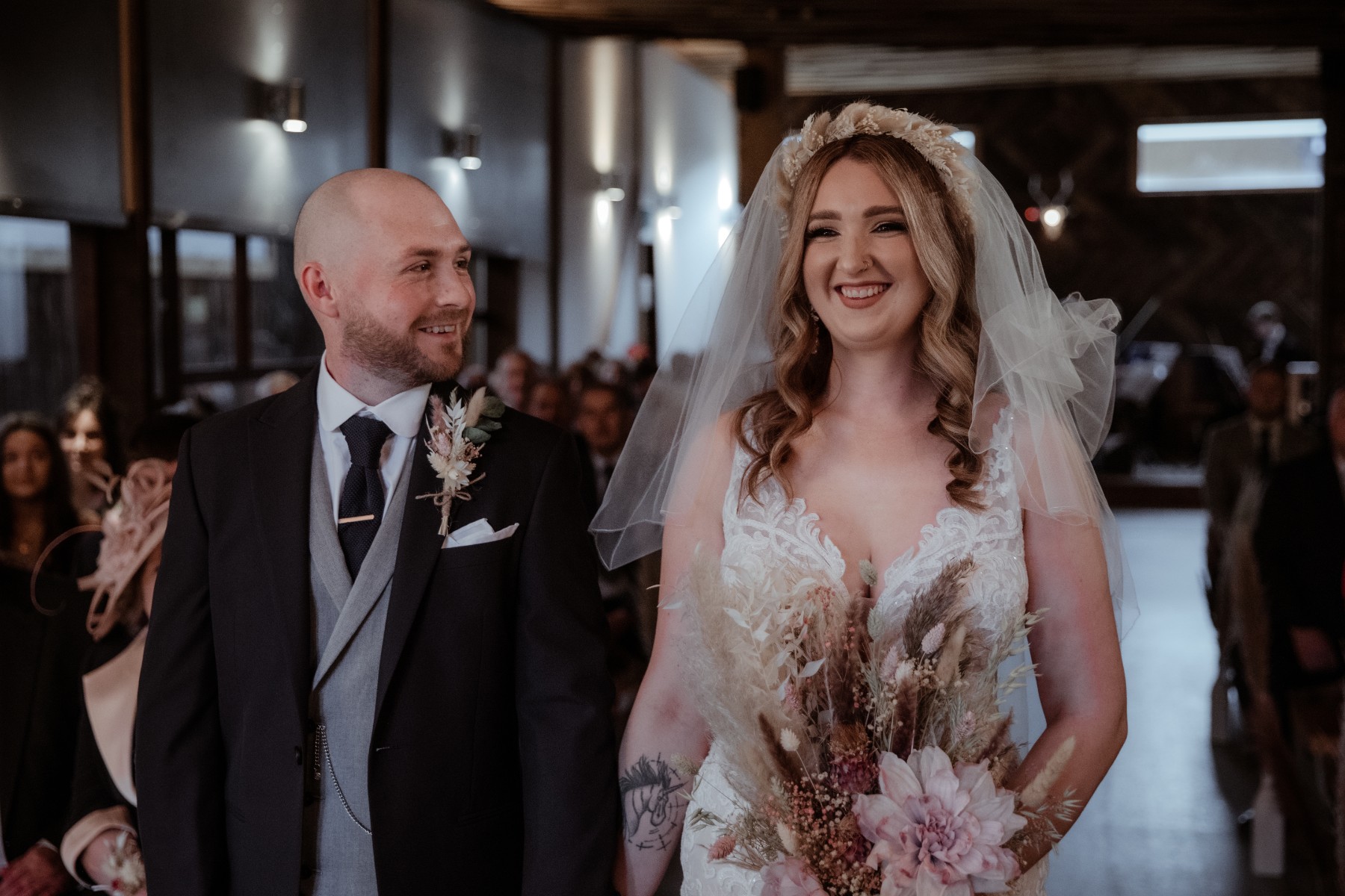 bride and groom smile as they stand at the altar at Owen House Wedding Barn