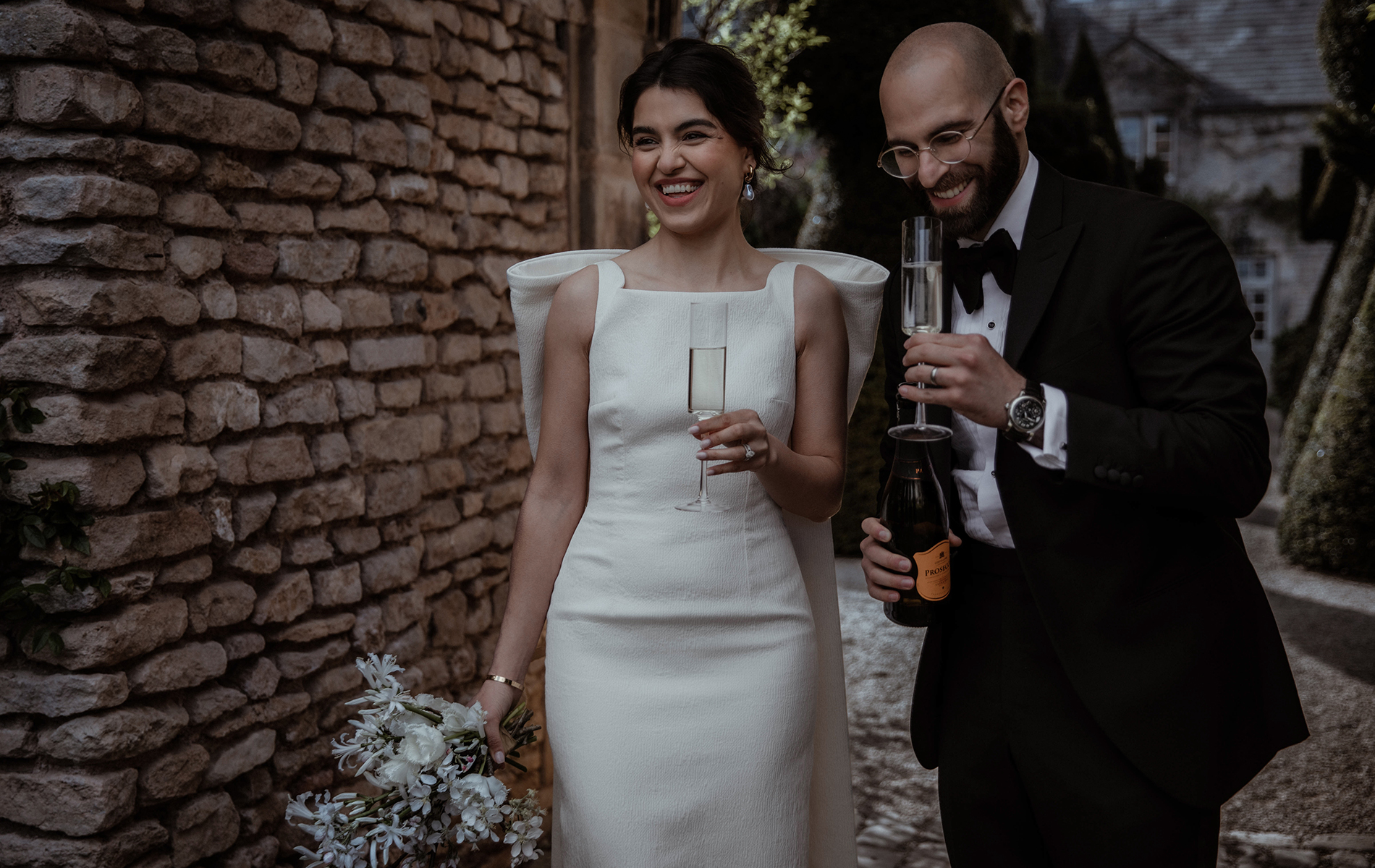 new husband and wife laugh and sip champagne